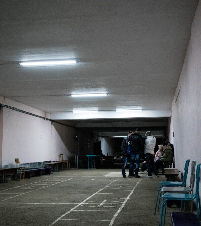 a group of people standing in a room with a tile floor